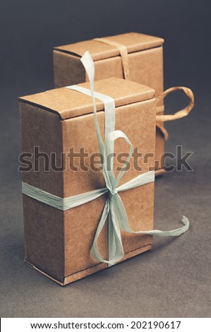 brown gift boxes with colored tape on grey background