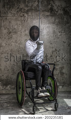 girl athlete in mask with sword in wheelchair on grey background