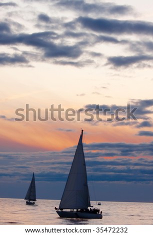 Sailboats at sunset, calm autumn weather in open sea