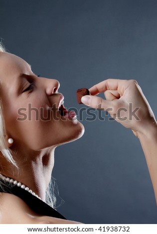 Portrait of sexy blonde eating candy