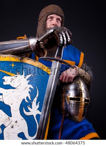Image of warrior holding his helmet and shield with sword