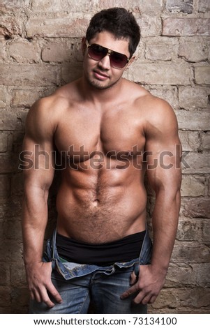 Portrait of a muscular man posing against old wall