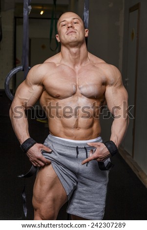 Strong muscular man bodybuilder poses and shows his muscles