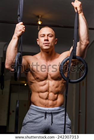 Strong muscular man bodybuilder poses and shows his body