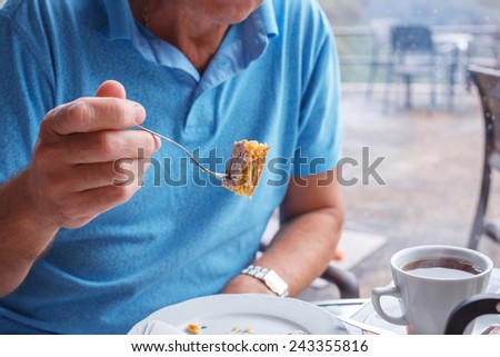 Male holds fork with tasty piece of cake
