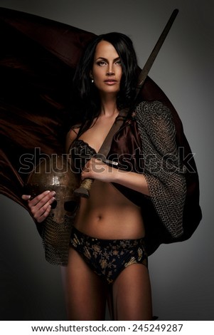 Beautiful female warrior holding sword and helmet