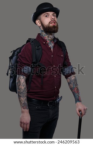 Tattooed male with bag and cane
