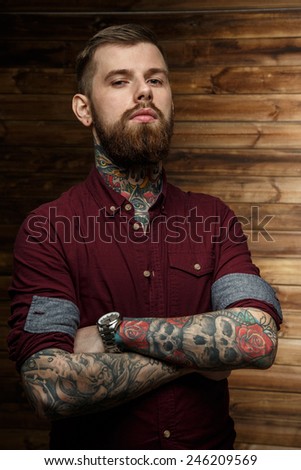Brutal tattooed man with full seriousness look