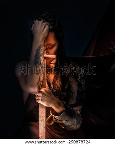 Portrai of mystic  elf woman with sword, armor and tattoo on her hand.