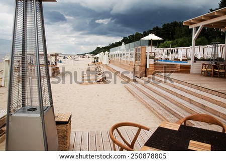 Summer terrace for relaxation  on  open air in the summer beach with wooden chairs, tables, sofas and sun umbrellas.
