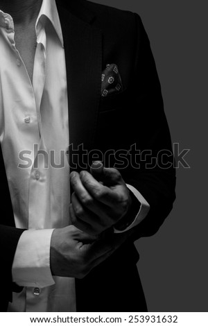 Part of  black and white portrait of male in a suit on dark grey background.