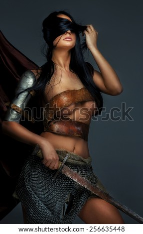 Awesome woman in Roman armor and sword. Isolated on grey.