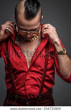 Crazy man in red t shirt glasses and tattoo on hands isolated on grey.