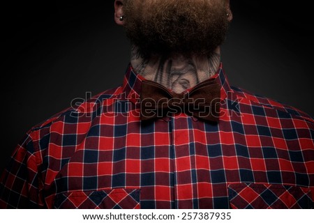 Part of face of the man with beard in red shirt and leopard bow tie. Isolated on dark gray background
