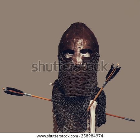 Skeleton of the dead warrior in the helmet and chain armour with arrows in his body