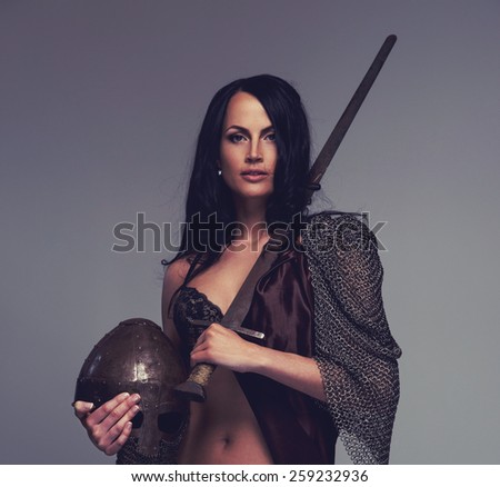Beautiful female warrior holding sword and helmet