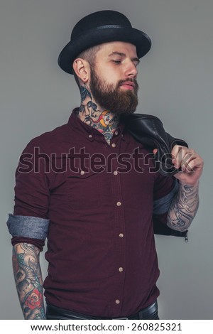Male with tattoos in red shirt and a hat