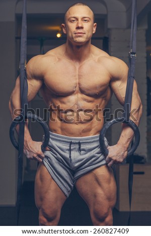 Strong muscular man bodybuilder poses and shows his body