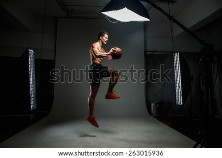 Male with basket ball in a jump in studio