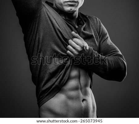 Muscular guy poses showing his abs and muscular body