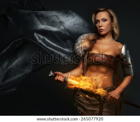 Middle age woman with sword in fire on grey background