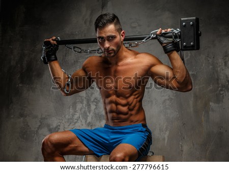 Shirtless muscular guy holding big hummer.