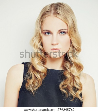 Portrait of serious blond female in black dress. Isolated on white background