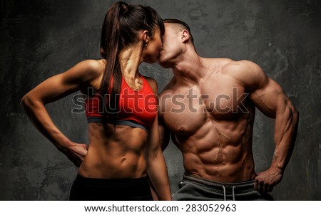 Bodybuilder kissing his fitness female
