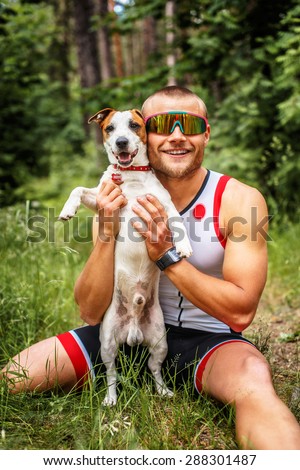 Fitness man in sportswear with his dog in the forest.