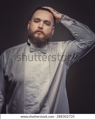 Brutal man in white shirt with bow tie. Isolated on grey