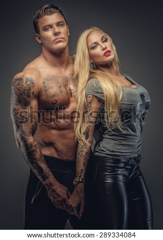 Couple of tattooed male and female. Isolated on grey background.