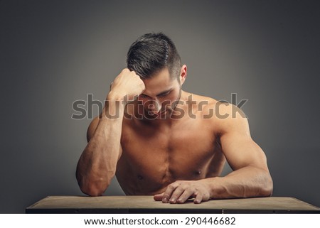 Shirtless guy thinking. Isolated on grey background