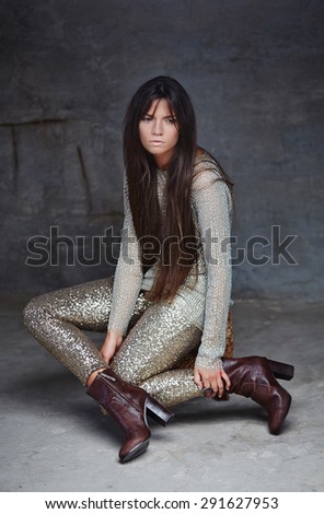 Girl in shiny clothes posing on camera.