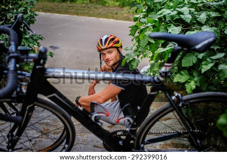 Happy man sitting on steps with sport bicycle in front of him.