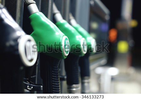 Green fuel pistols on fuel station.