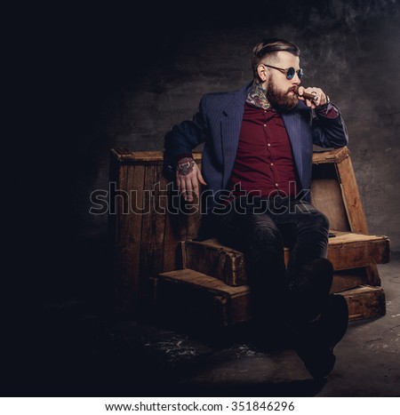Bearded hipster man in a suit smoking cigare.