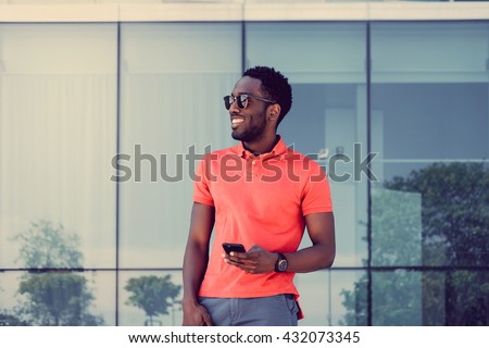 Afro american male in red t shirt texting sms on smartphone.