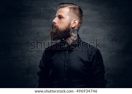 Studio portrait of bearded hipster male with tattoo on his neck.