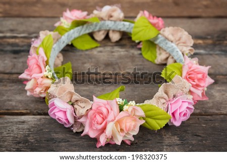 tiara of artificial roses on wooden background tiara of artificial roses on wooden background