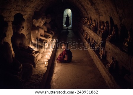 Mrauk-U, MYANMAR - DEC 15, 2014: Southeast Asian neophyte meditation with candle light in a Buddihist temple on December 15, 2014 in Mrauk-U, Myanmar.