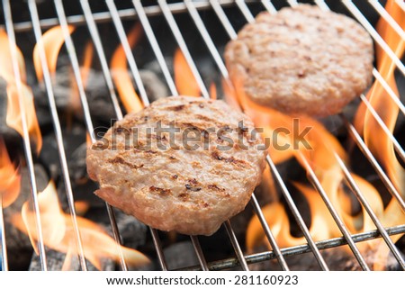 Hamburgers on Grill with Dancing Flames Cooked.