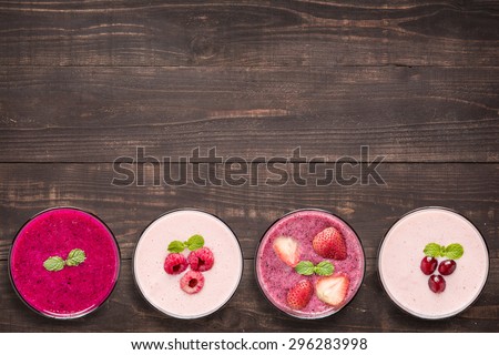 Set of fruit smoothie in glasses on wooden background