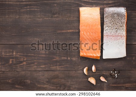 salmon with garlic on wooden background with a lot of copy space for your text or editing.