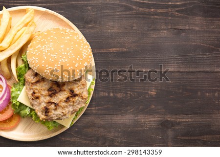 Top view bbq hamburger and french fries on the wooden background with a lot of copy space for your text or editing.