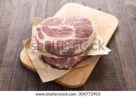 Raw fresh meat steak on wooden background.