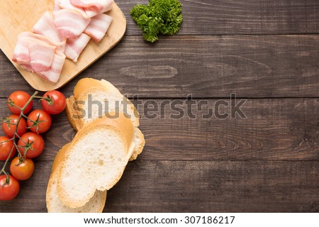 Ingredients for sandwich on wooden background.