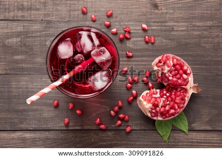 Ripe pomegranates with juice on wooden background.