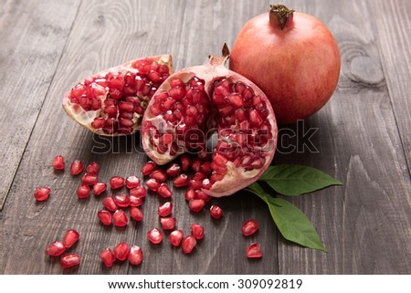 Ripe pomegranate fruit on wooden vintage table.