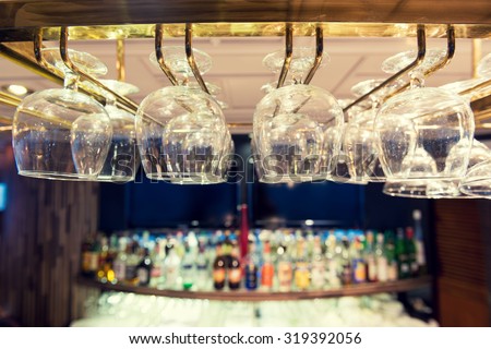 Empty wine glasses on the bar rack, Vintage filter.