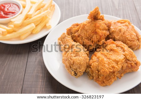 fried chicken and french fries on a wooden background.